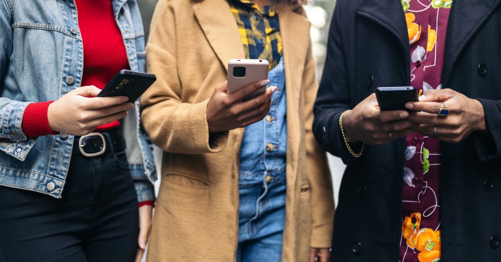 Three people using their phones